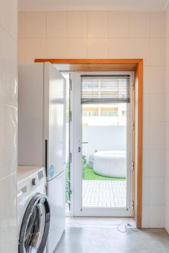 a kitchen with a door open to a tub at HostWise – Modern Flat w/ Terrace | Near the Beach in Matosinhos
