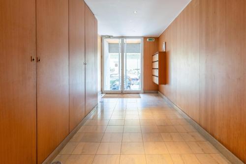 a hallway with wooden cabinets and a large window at HostWise – Modern Flat w/ Terrace | Near the Beach in Matosinhos