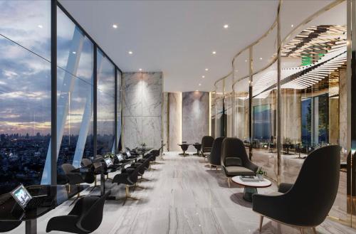 a room with chairs and tables and windows at The Rich Rama 9 Luxury Condos in Sathani Ban Hua Mak