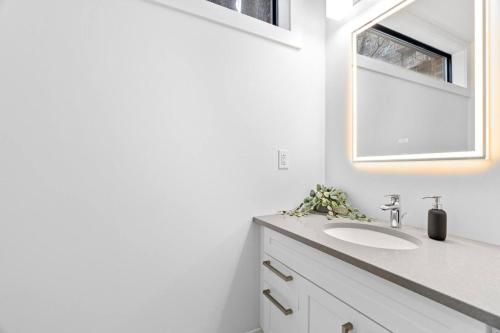 a bathroom with a sink and a mirror at RentX Cozy Downtown London Parking WiFi in London