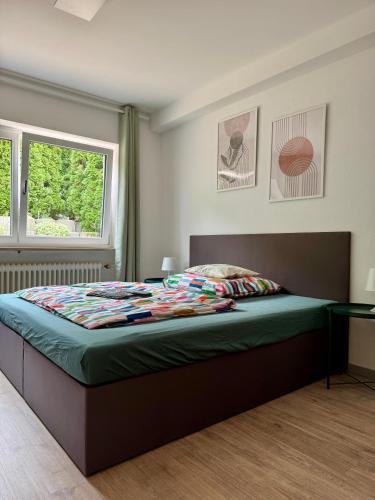 a bedroom with a bed with a green comforter at ausZEITlarn - Apartment in Zeitlarn