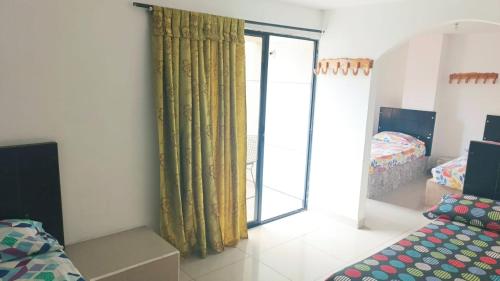 a room with a bed and a sliding glass door at Hotel San José Medellín in Medellín
