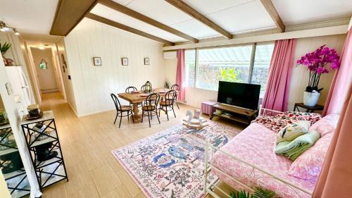 ein Wohnzimmer mit Sofa und Tisch in der Unterkunft Oceanfront Stay w/ AC, BBQ, Washer/Dryer & Kitchen in Ewa Beach