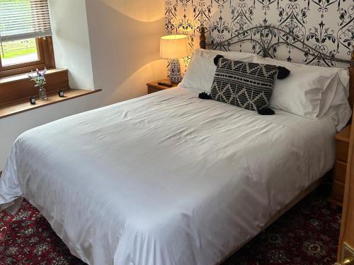 a bedroom with a large white bed with a window at Swaledale Watch Garden Annexe in Wigton