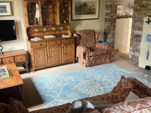 a living room with a couch and a chair at Swaledale Watch Garden Annexe in Wigton