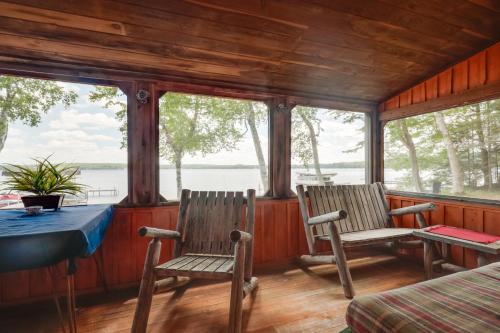 two chairs and a table in a room with windows at South Twin Lake Cabin with Seasonal Dock and Slip! in Conover