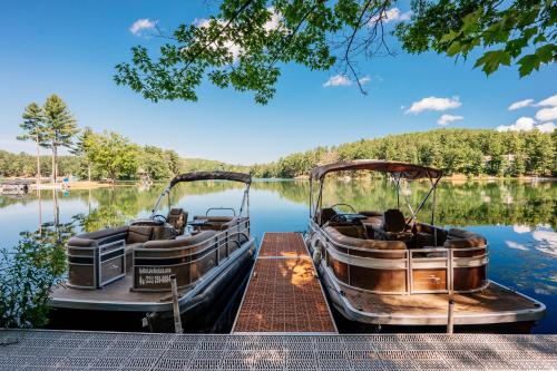 two boats are parked on a dock on a lake at Arbutus Lake-King Suite-Pontoon Rentals in Traverse City