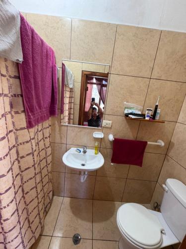 a bathroom with a toilet and a sink and a mirror at El Paraiso in Puerto Ayora