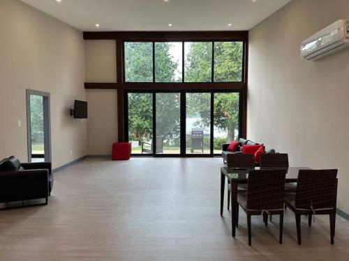 a living room with a table and chairs and windows at 3-bedroom Lakefront Villa #3 in Lakefield