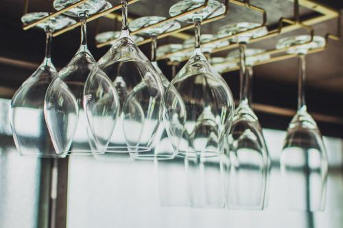a bunch of wine glasses hanging from a rack at サウナとアートの宿 瀬戸内一棟貸切 Sei-Jima Retreat in Sakaide