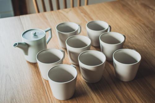 a group of white cups sitting on a table at サウナとアートの宿 瀬戸内一棟貸切 Sei-Jima Retreat in Sakaide