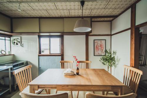 a dining room with a wooden table and chairs at サウナとアートの宿 瀬戸内一棟貸切 Sei-Jima Retreat in Sakaide