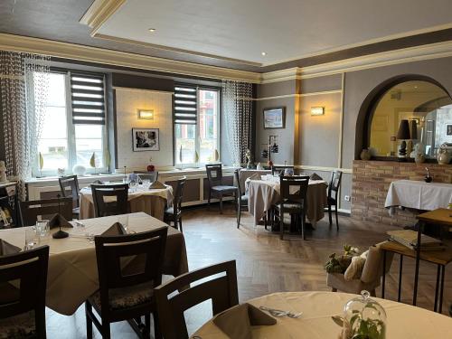 a dining room with tables and chairs in a restaurant at Logis Hotel & Restaurant - Hostellerie du Prieuré in Saint-Quirin