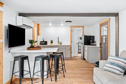 a kitchen and living room with a bar and stools at Arbutus Lake-Pine Forest-Pontoon Rentals in Traverse City
