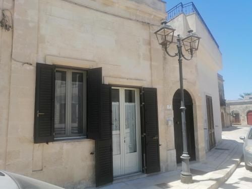 a building with black doors and a street light at A casa di Marisa in Casamassella