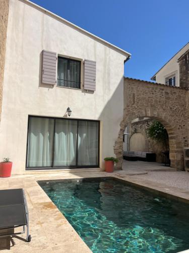 une piscine devant une maison dans l'établissement ARCHE DE PEZENAS, à Pézenas