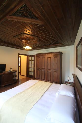 a large bed in a bedroom with a wooden ceiling at Boutique Hotel Muzaka (Historic Center) in Berat