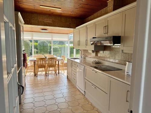 a kitchen with white cabinets and a table with chairs at Forest Cottage in Newcastle