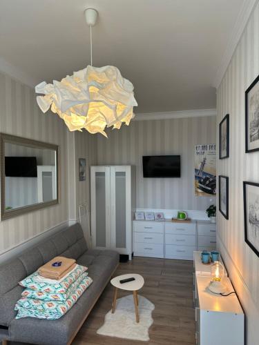 a living room with a couch and a chandelier at Happy8 in Gdynia