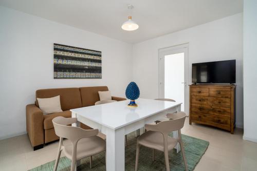 a living room with a white table and chairs at Villademar lunarossa in Marzamemi