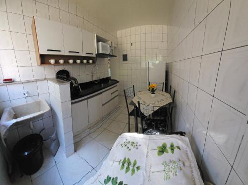 a small kitchen with a table and a sink at Apartamento temporada 2 quartos em Vila Velha in Vila Velha