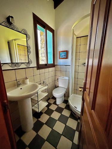 ein Badezimmer mit Waschbecken, Toilette und Spiegel in der Unterkunft Villarrodrigo in Cangas de Onís