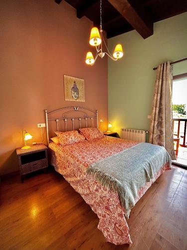 ein Schlafzimmer mit einem Bett und einem Kronleuchter in der Unterkunft Villarrodrigo in Cangas de Onís