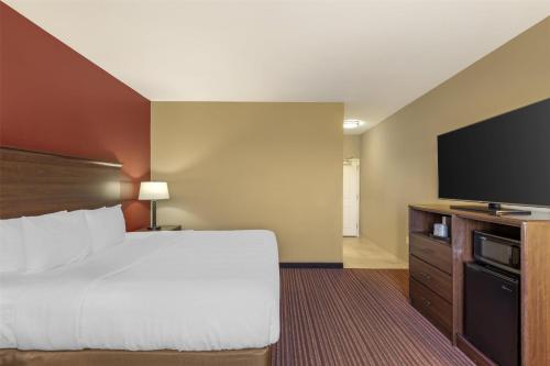 a hotel room with a bed and a flat screen tv at Best Western Plus Hudson Hotel & Suites in Hudson