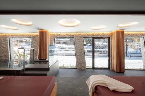 a living room with large windows and a couch at Stella Alpina Chalet in Madonna di Campiglio