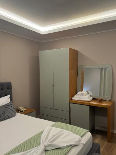 a bedroom with a bed and a dresser and a mirror at Vila Park Hotel 1 in Tirana