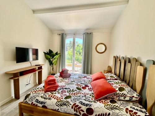 une chambre avec un lit, une télévision et une fenêtre dans l'établissement Les Restanques Maison 3 Pins, à Grimaud