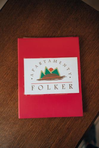 a red book on a table with a marauder logo at Rodzinny apartament FOLKER in Węgierska Górka