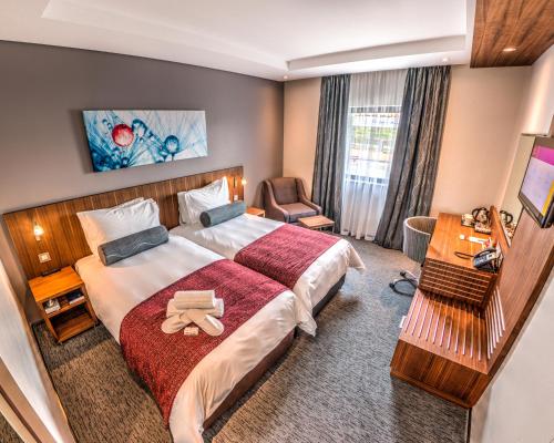 una camera d'albergo con un grande letto e una sedia di City Lodge Hotel Waterfall City a Midrand