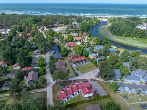 an aerial view of a suburb with a river and houses at Apartamentai Trys pušys in Šventoji