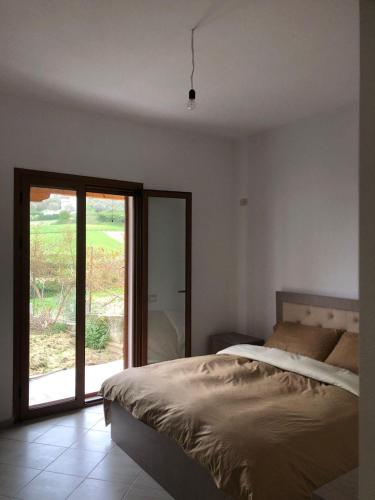 a bedroom with a bed and a sliding glass door at Vila Mehalla in Arape-Rashbulli