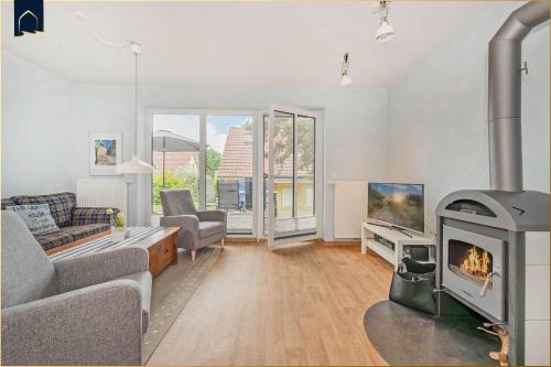 a living room with a fireplace and a couch at Waldsiedlung DHH Waldhaus 5 in Korswandt