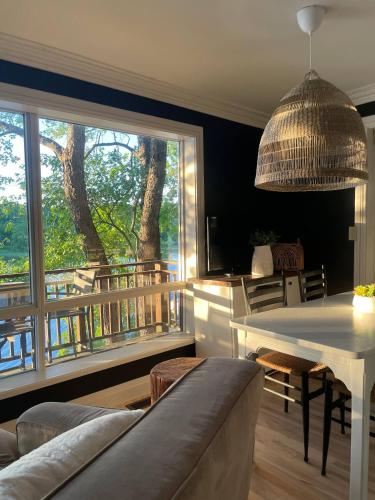 a living room with a table and a large window at The Muskoka Nest in Windermere
