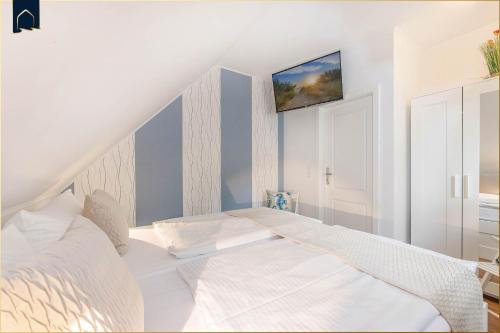 a bedroom with a white bed in a attic at Waldsiedlung DHH Waldhaus 5 in Korswandt
