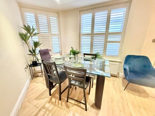 a dining room with a glass table and chairs at 3-Bedroom Apartment with private Terrace in Pimlico, Westminster & Victoria by Staylio London in London