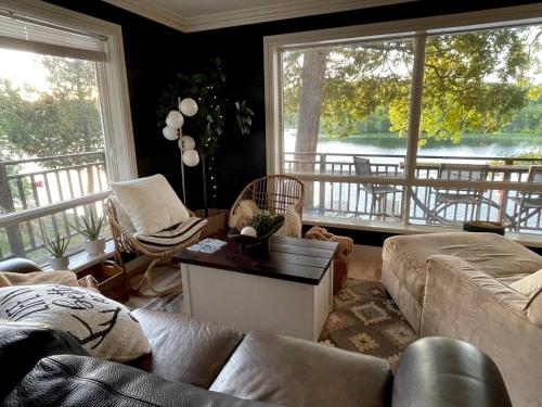 a living room with a couch and chairs and windows at The Muskoka Nest in Windermere