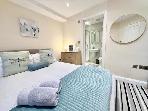 a bedroom with a large bed and a mirror at 3-Bedroom Apartment with private Terrace in Pimlico, Westminster & Victoria by Staylio London in London