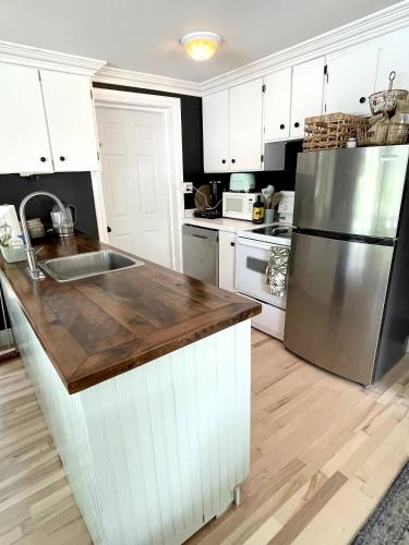 a kitchen with white cabinets and a stainless steel refrigerator at The Muskoka Nest in Windermere