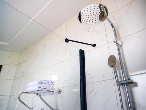 a shower with a shower head in a bathroom at Hôtel KEMAKA in Abidjan