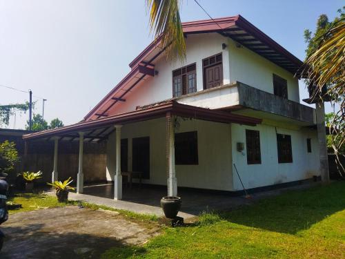 a white house with a red roof at Supra villa in Ginimellagaha West