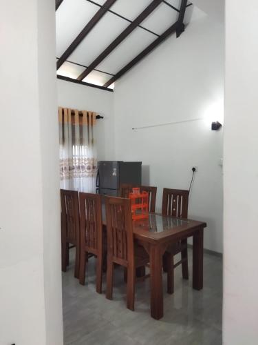 a dining room with a wooden table and chairs at Supra villa in Ginimellagaha West