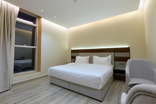 a bedroom with a large white bed and a window at شقق منازل بلقيس للشقق المخدومة الآثير in Hail