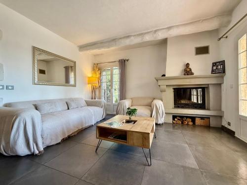 un salon avec un canapé et une cheminée dans l'établissement Maison dans résidence avec piscine et tennis, à Antibes