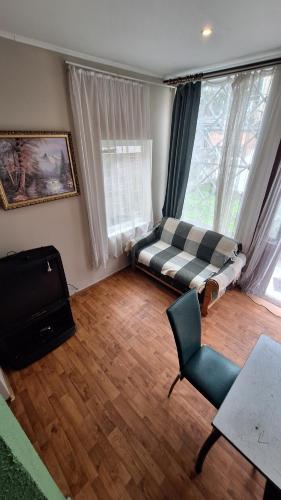 a living room with a bed and a chair at Apartments Londa in Jūrmala