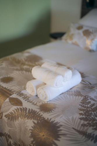 a group of rolled up towels on a bed at Les Ti Kaz d'Auguste in Les Avirons