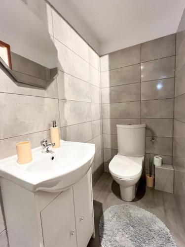 a bathroom with a white sink and a toilet at Domki Letniskowe Ster in Międzyzdroje